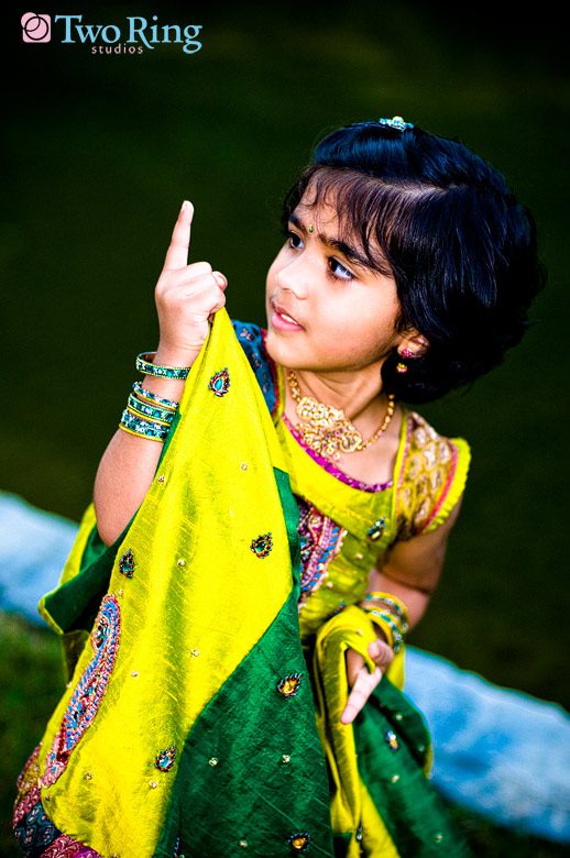 little Indian girl in traditional green and gold wedding attire 