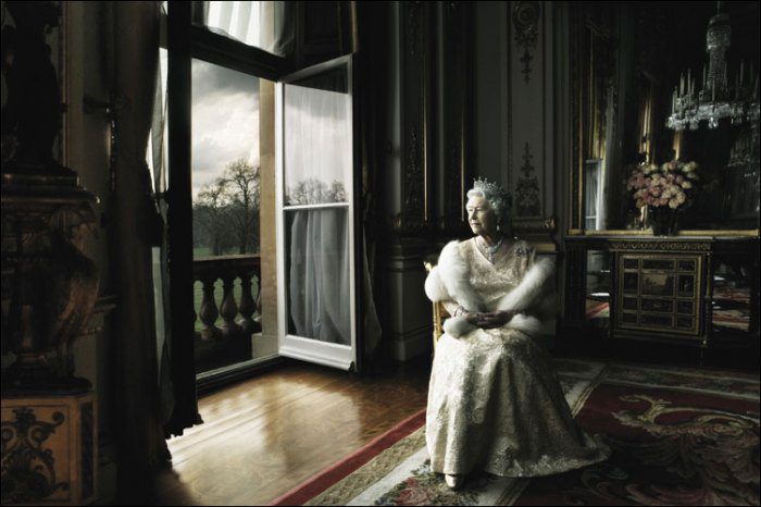 Queen Elizabeth sits in a chair looking out the window