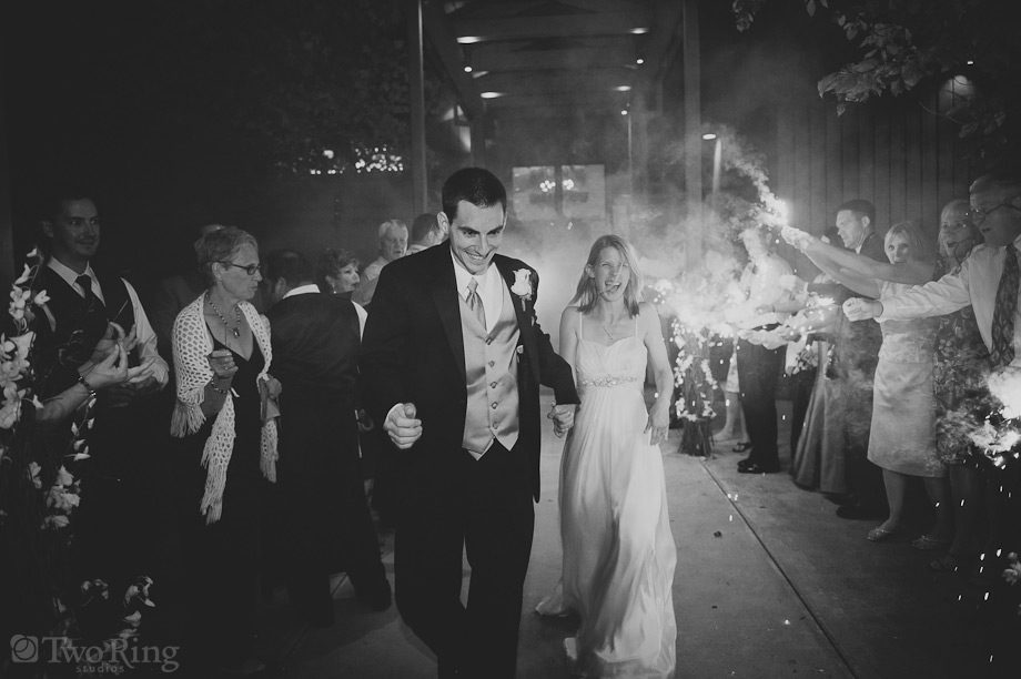 Bride and groom leave Crest Center through line of sparklers